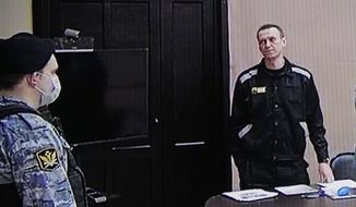 Russian opposition leader Alexei Navalny, right, is seen via a video link provided by the Russian Federal Penitentiary Service, standing during a court session in Pokrov, Vladimir region, about 100 kilometers (62 miles) east of Moscow, Russia, Tuesday, March 22, 2022. The Russian authorities are seeking a 13-year prison sentence for Navalny in a trial that Kremlin critics see as an attempt to keep President Vladimir Putin&#39;s most ardent foe in prison for as long as possible. (AP Photo/Alexander Zemlianichenko)