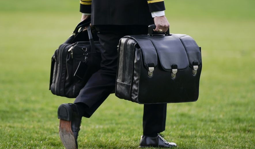 A military aide carries the &quot;President&#39;s emergency satchel,&quot; also known as &quot;the football,&quot; which contains nuclear launch codes, before boarding Marine One behind President Joe Biden on the South Lawn of the White House, Wednesday, March 23, 2022, in Washington. Biden is traveling to Europe to meet with World counterparts on Russia&#39;s invasion of Ukraine. (AP Photo/Patrick Semansky)