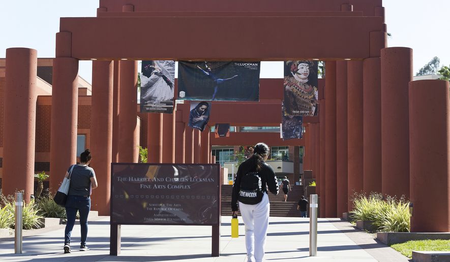 Students walk past the Harriet and Charles Luckman Fine Arts Complex at the Cal State University, Los Angeles campus on April 25, 2019. California State University, the country&#x27;s largest four-year university system, will eliminate SAT and ACT standardized tests from its admission requirements in a move that places California&#x27;s public universities at the forefront of a national trend to drop the exams. (AP Photo/Damian Dovarganes, File)