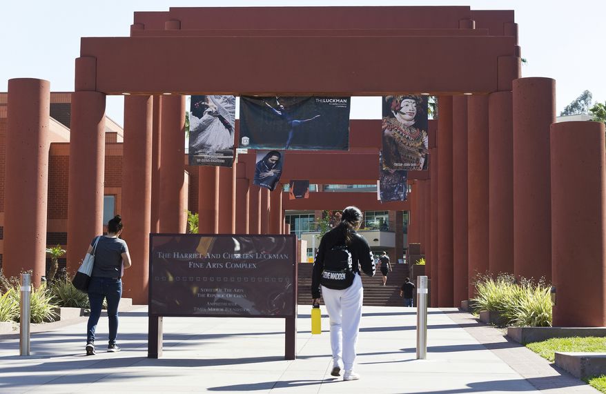 Students walk past the Harriet and Charles Luckman Fine Arts Complex at the Cal State University, Los Angeles campus on April 25, 2019. California State University, the country&#x27;s largest four-year university system, will eliminate SAT and ACT standardized tests from its admission requirements in a move that places California&#x27;s public universities at the forefront of a national trend to drop the exams. (AP Photo/Damian Dovarganes, File)