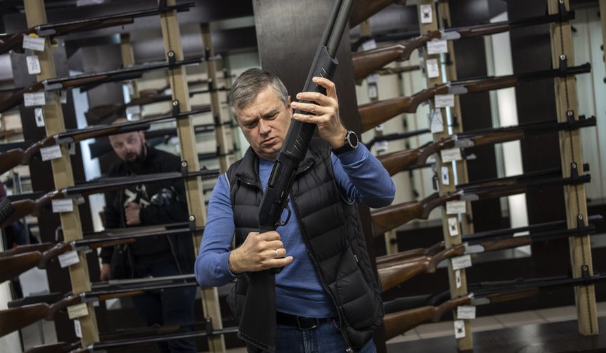 A customer checks his rifle in a gun shop in Lviv, western Ukraine, Wednesday, March 23, 2022. The rush for guns and gun training continued in the western city of Lviv. (AP Photo/Bernat Armangue)