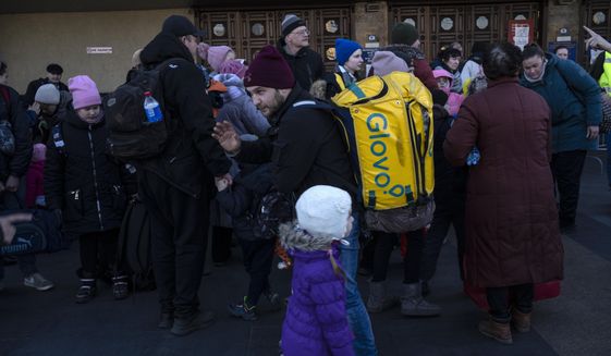Families arrive at Kyiv&#39;s train station after leaving their homes in Chernihiv, Ukraine, through a humanitarian corridor, Monday, March 21, 2022. (AP Photo/Rodrigo Abd)