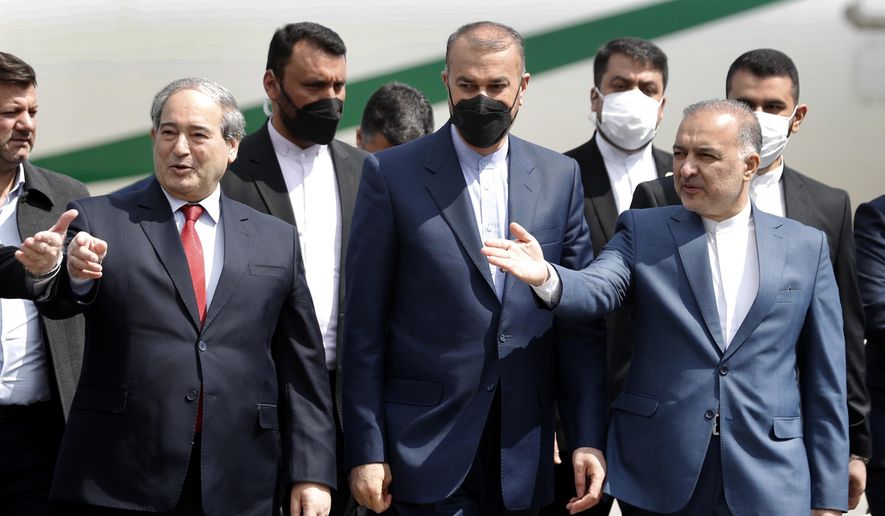 Syria&#39;s Foreign Minister Faisal Mekdad, left, receives his Iranian counterpart Hossein Amir-Abdollahian, center, upon his arrival at the airport in Damascus, Syria, Wednesday, March 23, 2022. The foreign ministers of Iran and Syria, two allies of Russia, will discuss the ongoing war in Ukraine and other developments during a meeting in Damascus Wednesday, Syria&#39;s foreign minister said. (AP Photo/Omar Sanadiki)