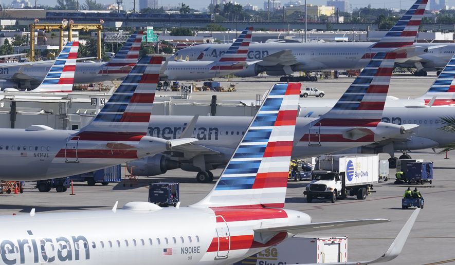 American Airlines planes are parked at Miami International Airport gates, Tuesday, Nov. 23, 2021, in Miami. (AP Photo/Marta Lavandier)