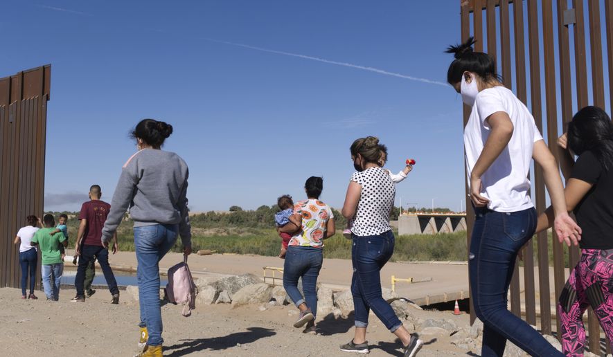 A group of Brazilian migrants make their way around a gap in the U.S.-Mexico border in Yuma, Ariz., seeking asylum in the United States after crossing over from Mexico, June 8, 2021. border.  (AP Photo/Eugene Garcia, File)  **FILE**