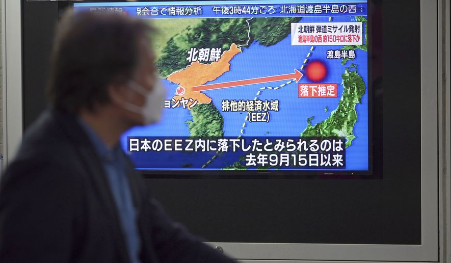 A man walks along a sidewalk past a TV showing a news program on North Korea&#x27;s missile launch Thursday, March 24, 2022, in Tokyo. North Korea has fired a suspected long-range missile toward the sea in what would be its first such test since 2017, raising the ante in a pressure campaign aimed at forcing the United States and other rivals to accept it as a nuclear power and remove crippling sanctions. (AP Photo/Eugene Hoshiko)