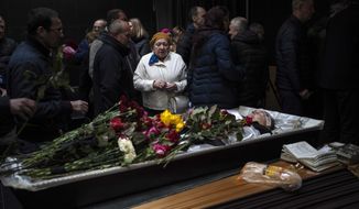 Natalya, center, looks at her brother Sergiy Muravyts&#39;kyi, 61, who was killed by Russian soldiers in the village of Mriya, which means Dream in Ukrainian, during a ceremony before his cremation in Baikove cemetery, Kyiv, Ukraine, Thursday, March 24, 2022. (AP Photo/Rodrigo Abd)