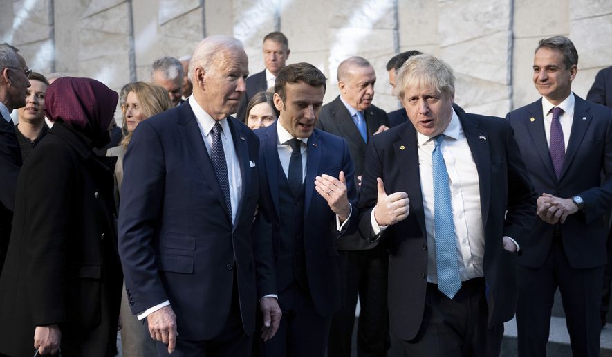 President Joe Biden, left, talks with French President Emmanuel Macron and Briitish Prime Minister Boris Johnson, right, as they arrive at NATO Headquarters in Brussels, Thursday, March 24, 2022. (Brendan Smialowski, Pool via AP)