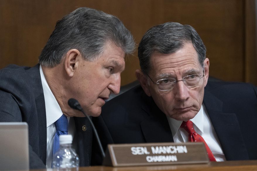 Chairman Joe Manchin, D-W.Va., left, and Sen. John Barrasso, R-Wyo., talk during a hearing of the Senate Energy and Natural Resources Committee on Capitol Hill, Wednesday, March 10, 2022, in Washington. (AP Photo/Alex Brandon) **FiLE**