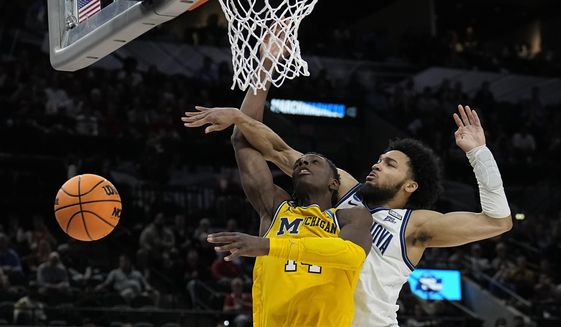 Villanova guard Caleb Daniels, right, fouls Michigan forward Moussa Diabate during the second half of a college basketball game in the Sweet 16 round of the NCAA tournament on Thursday, March 24, 2022, in San Antonio. (AP Photo/Eric Gay)