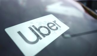 An Uber sign is displayed inside a car in Palatine, Ill., Thursday, Feb. 10, 2022. Uber has reached a deal to include New York City taxi cabs on its app, a move that will help to boost driver availability for passengers and open up a new set of customers for cab drivers. (AP Photo/Nam Y. Huh) ** FILE **