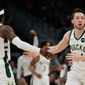 Milwaukee Bucks&#39; Pat Connaughton is congratulated by Wesley Matthews after making a shot during the first half of an NBA basketball game Tuesday, Feb. 22, 2022, in Milwaukee . (AP Photo/Morry Gash)