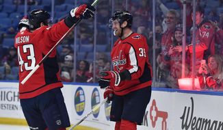 Washington Capitals right wing Anthony Mantha, right, celebrates with right wing Tom Wilson after scoring against the Buffalo Sabres during the first period of an NHL hockey game in Buffalo, N.Y., Friday, March 25, 2022. (AP Photo/Adrian Kraus)