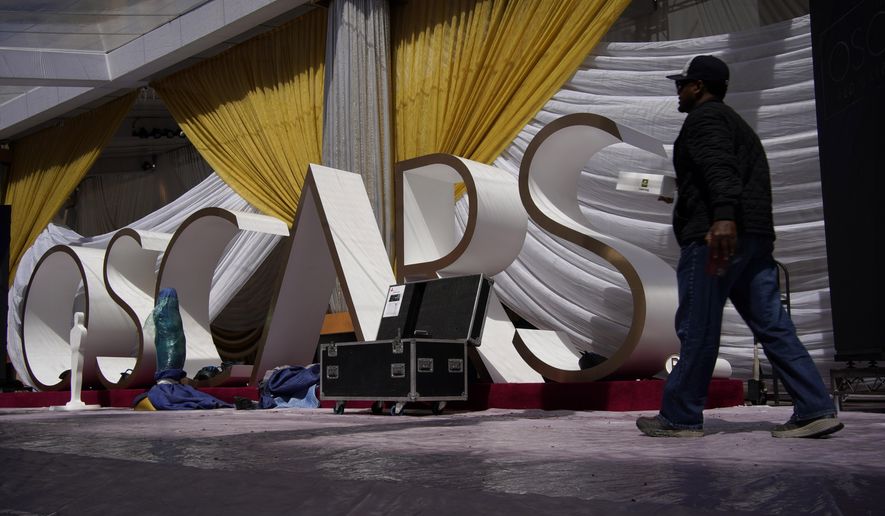 A person walks along the red carpet during preparations for Sunday's 94th Academy Awards outside the Dolby Theatre on Friday, March 25, 2022, in Los Angeles. (AP Photo/John Locher)