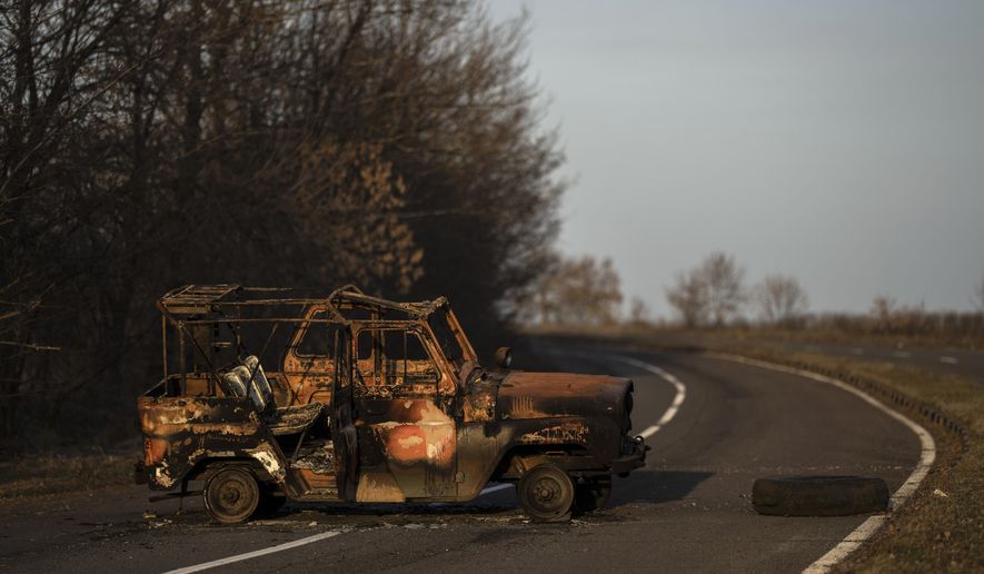 A burned Ukranian army vehicle stands on a street leading to the airport of the city of Mykolaiv, Ukraine, Friday, 25, 2022.(AP Photo/Petros Giannakouris)
