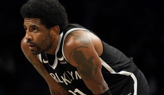 Brooklyn Nets guard Kyrie Irving (11) stands on the court during a break in play in the first half of an NBA basketball game against the Charlotte Hornets, Sunday, March 27, 2022, in New York. (AP Photo/John Minchillo)