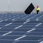 Electricians with IBEW Local 3 install solar panels on top of the Terminal B garage at LaGuardia Airport, Nov. 9, 2021, in the Queens borough of New York. (AP Photo/Mary Altaffer, File)