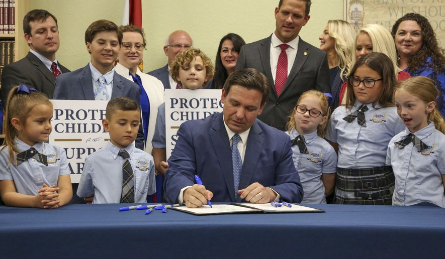 Florida Gov. Ron DeSantis signs the Parental Rights in Education bill at Classical Preparatory school Monday, March 28, 2022 in Shady Hills, Fla. (Douglas R. Clifford/Tampa Bay Times via AP)