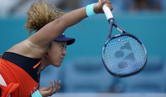Naomi Osaka, of Japan, serves to Alison Riske during the Miami Open tennis tournament, Monday, March 28, 2022, in Miami Gardens, Fla. (AP Photo/Wilfredo Lee)