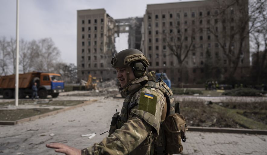 A Ukrainian soldier secures the area next to the regional government headquarters of Mykolaiv, Ukraine, following a Russian attack, on Tuesday, March 29, 2022. Ukrainian President Volodymyr Zelenskyy says seven people were killed in a missile strike on the regional government headquarters in the southern city of Mykolayiv. (AP Photo/Petros Giannakouris)