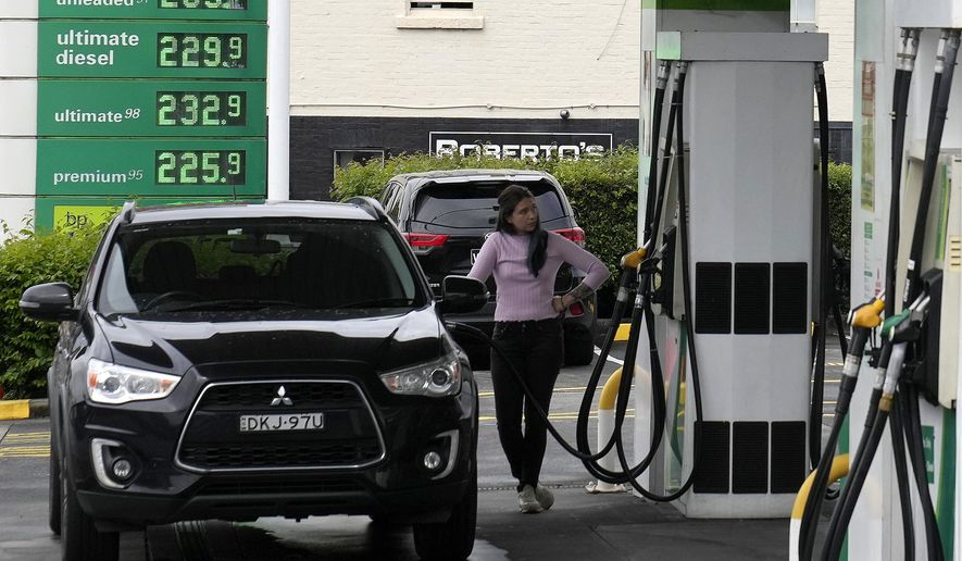 A woman pumps fuel into her vehicle at a service station in Sydney, Tuesday, March 29, 2022. With inflation increasing in Australia and many parts of the world driven in part by higher oil prices, the government is expected to reduce its 44.2 Australian cents (33.1 U.S. cents) a liter ($1.25 a gallon) tax on gasoline. (AP Photo/Rick Rycroft)