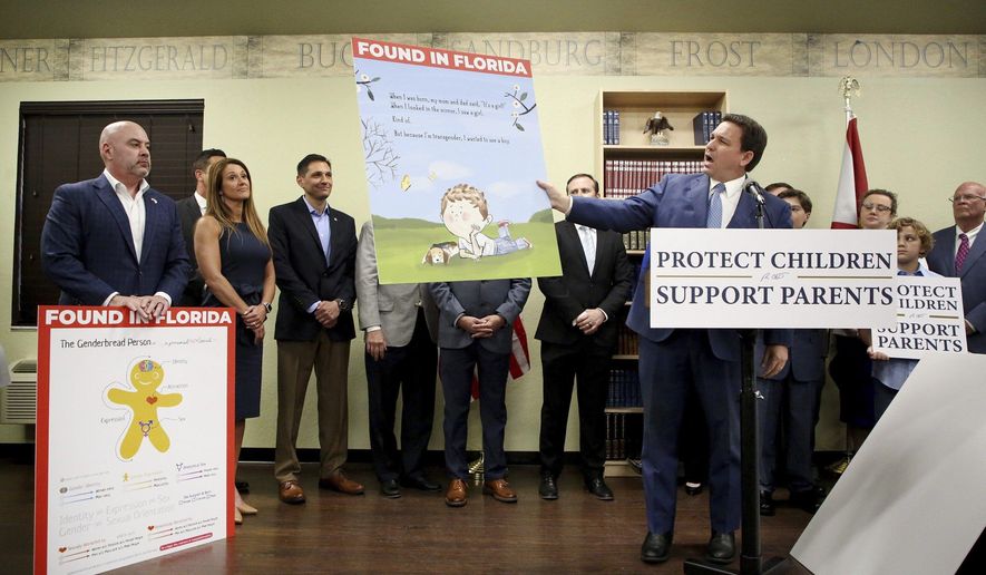 Florida Gov. Ron DeSantis shows an image from the children&#39;s book Call Me Max by transgender author Kyle Lukoff moments before signing the Parental Rights in Education bill during a news conference on Monday, March 28, 2022, at Classical Preparatory school in Shady Hills. At left is an image of The Genderbread Person, a teaching tool used for breaking the concept of gender. (Douglas R. Clifford/Tampa Bay Times via AP)