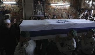 Israeli border police officers carry the flag-draped coffin of Druze Israeli border police officer Yezen Falah, 19, during his funeral in the village of Kisra-Sumei, northern Israel, Monday, March 28, 2022. Falah was killed in a Sunday night shooting attack by a pair of Arab gunmen, in the central Israel city of Hadera that police say killed two people and wounded four. The militant Islamic State group has claimed responsibility for the attack and the shooters were killed by police. (AP Photo/Ariel Schalit)