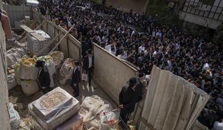 Mourners gather around the body of Avishai Yehezkel, 29, during his funeral in Bnei Brak Israel, Wednesday, March 30, 2022. Yehezkel was one of five killed by a gunman in a crowded city in central Israel late Tuesday, the second mass shooting rampage this week. The shooter was killed by police. (AP Photo/Oded Balilty)