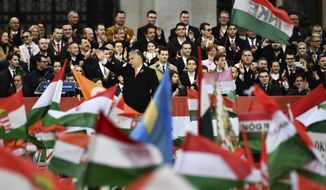 Hungary&#39;s right-wing populist prime minister, Viktor Orban, center, greets thousands of supporters as they gather in Budapest, Hungary, Tuesday, March 15, 2022. The so-called &amp;quot;peace march&amp;quot; was a show of strength by Orban&#39;s supporters ahead of national elections scheduled for April 3, while a coalition of six opposition parties also held a rally in the capital. (AP Photo/Anna Szilagyi)