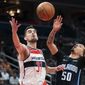 Washington Wizards guard Tomas Satoransky (31) and Orlando Magic guard Cole Anthony (50) reach for the ball during the first half of an NBA basketball game Wednesday, March 30, 2022, in Washington. (AP Photo/Alex Brandon)