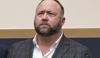FILE - This Tuesday, Dec. 11, 2018, file photo shows radio show host and conspiracy theorist Alex Jones at Capitol Hill in Washington. Infowars host Jones has offered to pay $120,000 per plaintiff to resolve a lawsuit by relatives of Sandy Hook Elementary School shooting victims who said he defamed them by asserting the massacre never happened, according to court filings Tuesday, March 29, 2022. (AP Photo/J. Scott Applewhite, File)