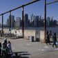 People enjoy the sunny weather and a view of the Manhattan skyline from the Brooklyn waterfront, March 21, 2021, in New York. A judge has ordered New York&#x27;s Democrat-controlled Legislature to redraw the state&#x27;s congressional and legislative districts after finding they were unconstitutional. (AP Photo/Seth Wenig, File)