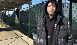 Elijah Ramos stands outside the the Amazon fulfillment center in Staten Island borough of New York at a bus stop on March 16, 2022. An independent group formed by former and current Amazon workers are trying to unionize a company warehouse in New York City. If successful, the effort at the Amazon fulfillment center in Staten Island could lead to the first unionized Amazon facility in the U.S.  (AP Photo/Haleluya Hadero)