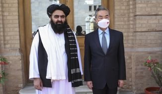 In this photo released by Xinhua News Agency, Chinese Foreign Minister Wang Yi, right, poses for photos with Amir Khan Muttaqi, acting foreign minister of the Afghan Taliban&#39;s caretaker government, in Kabul, Afghanistan on March 24, 2022. Chinese leader Xi Jinping on Thursday, March 31, 2022 issued strong backing for Afghanistan at a regional conference, while making no mention of human rights abuses by the country&#39;s Taliban leaders. (Saifurahman Safi/Xinhua via AP)