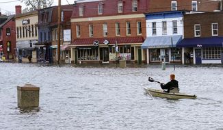 A person paddles their boat through a parking lot as they survey the flooding in downtown Annapolis, Md., Friday, Oct. 29, 2021. Maryland lawmakers gave final approval to a broad measure to reduce greenhouse gas emissions, sending the bill to Gov. Larry Hogan on Thursday, March 31, 2022.  (AP Photo/Susan Walsh, File)