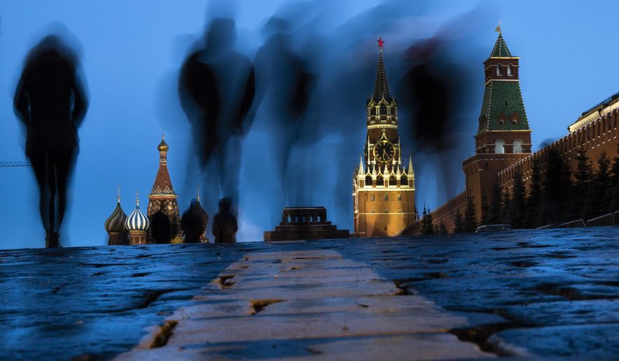 People walk through Red Square after sunset in Moscow, Russia, on March 3, 2019, with the St. Basil's left, and the Spasskaya Tower, second right, in the background. Russian technology workers are fleeing the country by the tens of thousands as the economy goes into a tailspin under pressure from international sanctions. For some countries, Russia’s loss is being seen as their potential gain and an opportunity to bring fresh expertise to their own high-tech industries. (AP Photo/Alexander Zemlianichenko, File)