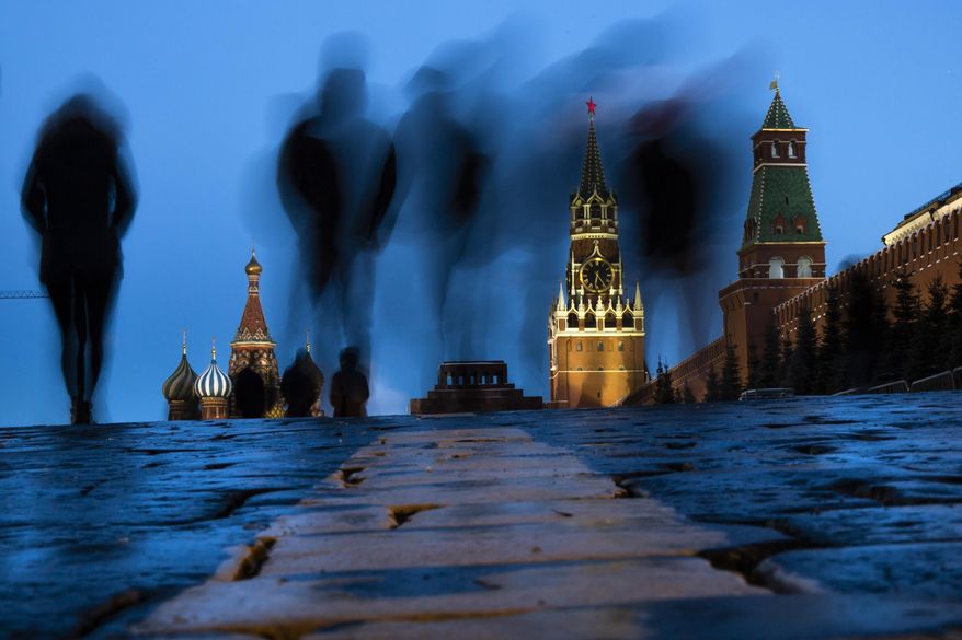 People walk through Red Square after sunset in Moscow, Russia, on March 3, 2019, with the St. Basil's left, and the Spasskaya Tower, second right, in the background. Russian technology workers are fleeing the country by the tens of thousands as the economy goes into a tailspin under pressure from international sanctions. For some countries, Russia’s loss is being seen as their potential gain and an opportunity to bring fresh expertise to their own high-tech industries. (AP Photo/Alexander Zemlianichenko, File)
