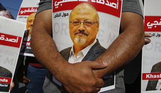 People hold posters of slain Saudi journalist Jamal Khashoggi, near the Saudi Arabia consulate in Istanbul, Oct. 2, 2020, marking the two-year anniversary of his death. In a surprise development, the prosecutor in the case against 26 Saudi nationals charged in the slaying of Washington Post columnist Jamal Khashoggi requested Thursday March 31, 2022, that their trial in absentia be suspended and the case be transferred to Saudi Arabia. (AP Photo/Emrah Gurel, File)