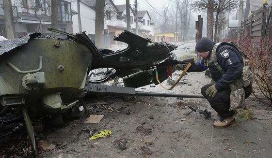 A Ukrainian soldier checks a destroyed Russian tank, in Irpin close to Kyiv, Ukraine, Friday, Apr. 1, 2022. Talks to stop the fighting in Ukraine resumed Friday, as another attempt to rescue civilians from the shattered and encircled city of Mariupol broke down and Russia accused the Ukrainians of a cross-border helicopter attack on an oil depot.  (AP Photo/Efrem Lukatsky)