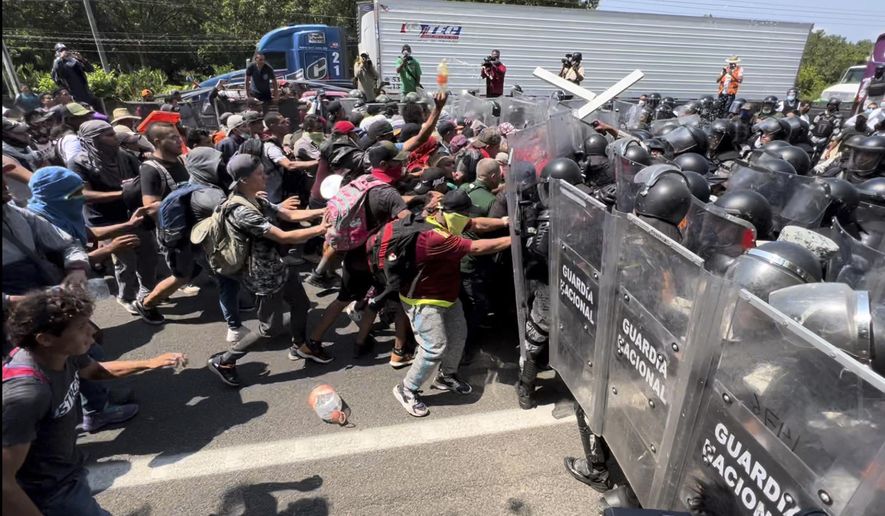 Migrant break through a line of National Guards trying to block them from leaving Tapachula, Mexico, Friday, April 1, 2022. Migrants have complained they have been essentially confined to Tapachula by the slow processing of their asylum cases and that they are unable to find work. (AP Photo/Edgar H. Clemente)