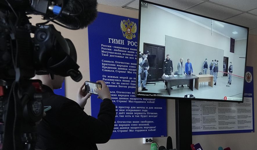FIL E- Journalists film a TV screen translating a court session of Russian opposition leader Alexei Navalny, in Pokrov, Vladimir region, east of Moscow, Russia, March 22, 2022. (AP Photo, File)