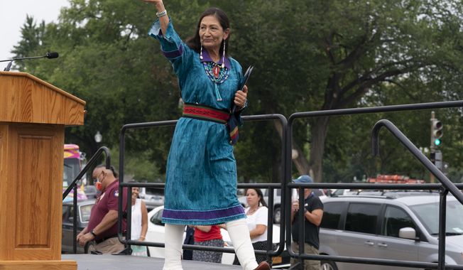 FILE - Interior Secretary Deb Haaland waves after speaking to a crowd during a totem pole delivery ceremony by Native American tribal leaders and Indigenous activists, on Capitol Hill in Washington on July 29, 2021. Secretary Haaland vowed on her first day on the job to ensure Native American tribes have opportunities to speak with her and the agencies she oversees. Native American and Alaska Native groups are seeing change under Haaland but some remain frustrated with the pace of action. (AP Photo/Jose Luis Magana, File)