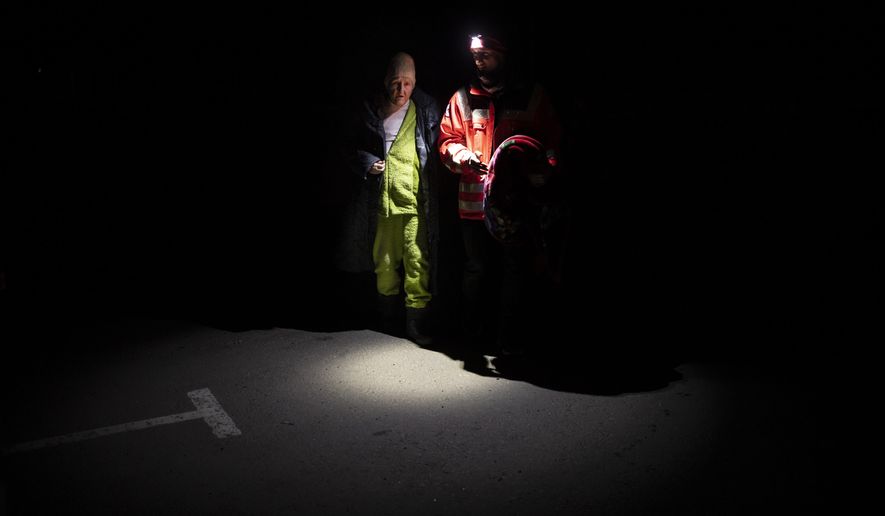 A Ukrainian Red Cross volunteers helps an elderly woman arriving from Mariupol at a refugee center in Zaporizhia, Ukraine, Friday, April 1, 2022. (AP Photo/Felipe Dana)
