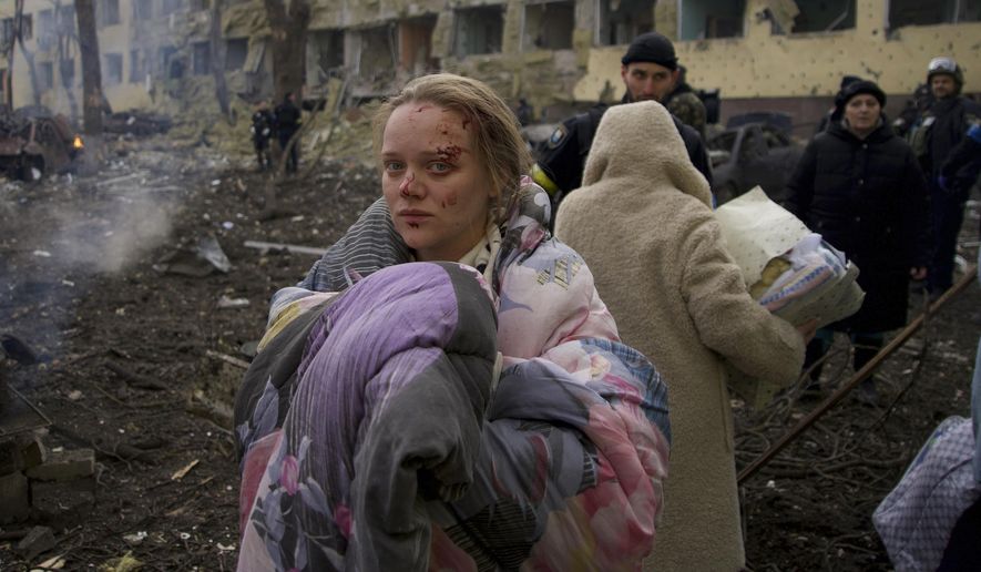 FILE - Marianna Vishegirskaya stands outside a maternity hospital that was damaged by shelling in Mariupol, Ukraine, Wednesday, March 9, 2022. Vishegirskaya, a Ukrainian beauty blogger who Russian officials accused of being a crisis actor when she was photographed in the rubble of a Mariupol maternity hospital a month earlier, has emerged in new videos that are fueling fresh misinformation about the attack. (AP Photo/Mstyslav Chernov, File)