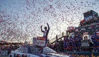 Denny Hamlin raises his hands in Victory Lane after winning the NASCAR Cup Series auto race at Richmond Raceway on Sunday, April 3, 2022, in Richmond, Va. (AP Photo/Mike Caudill)