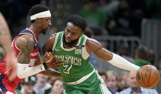 Washington Wizards guard Kentavious Caldwell-Pope, left, defends against Boston Celtics guard Jaylen Brown (7) in the second half of an NBA basketball game, Sunday, April 3, 2022, in Boston. (AP Photo/Steven Senne)