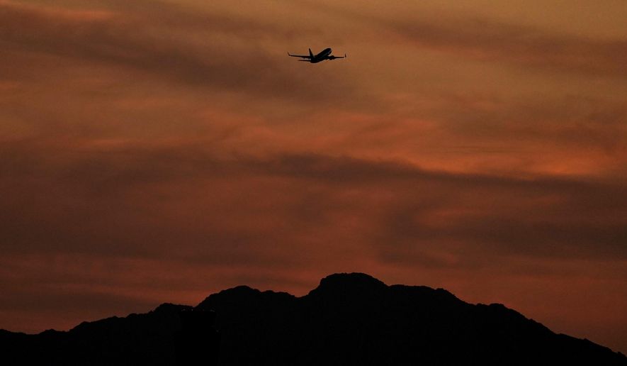 A passenger jet is silhouetted against the sky at dusk as it takes off from Sky Harbor Airport, Saturday, April 2, 2022, in Phoenix. Airlines have cancelled more than 3,300 U.S. flights this weekend and delayed thousands more, citing weather in Florida and other issues. (AP Photo/Charlie Riedel)