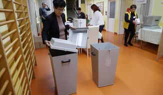 An election official checks a ballot box prior to sealing it at a local polling station in Nagykanizsa, Hungary, Sunday, April 3, 2022, before the start of the general election and national referendum on the child protection law. (Gyorgy Varga/MTI via AP)
