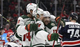 Minnesota Wild center Joel Eriksson Ek (14) celebrates his goal with left wing Marcus Foligno (17) and left wing Jordan Greenway (18) during the second period of the team&#39;s NHL hockey game against the Washington Capitals, Sunday, April 3, 2022, in Washington. (AP Photo/Nick Wass)