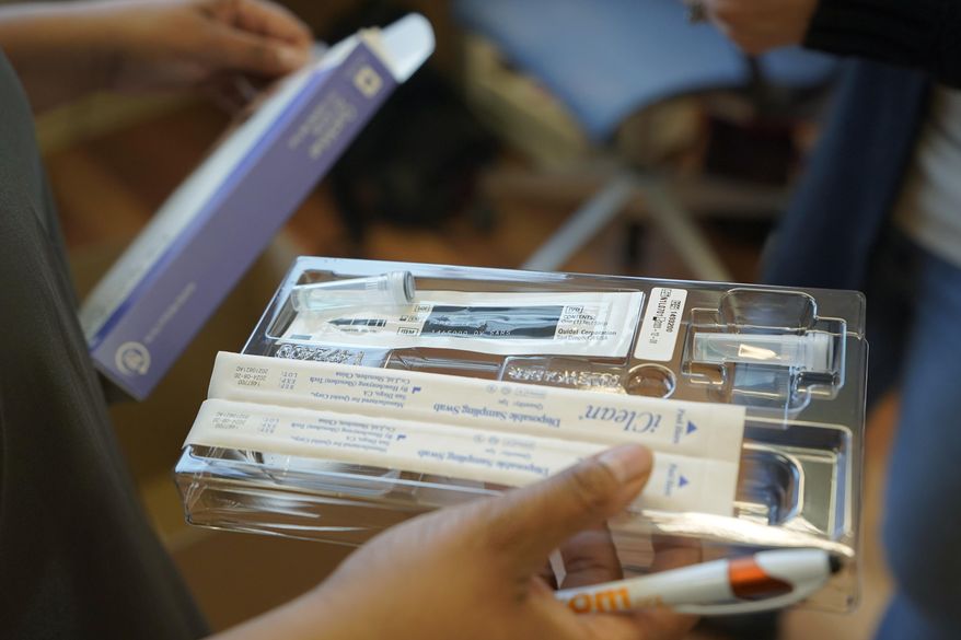A home COVID-19 test kit is held on Feb. 3, 2022, in Seattle. (AP Photo/Ted S. Warren, File)